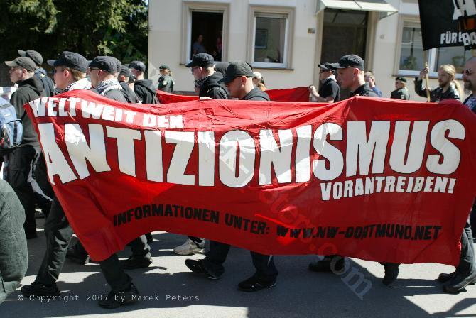 Neonazis mit antisemitischem Transparent "Weltweit den Antizionismus vorantreiben"