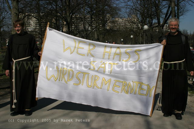 Mönche am Rande einer Neonazidemonstration mit Transparent "Wer Hass sät wird Sturm ernten"