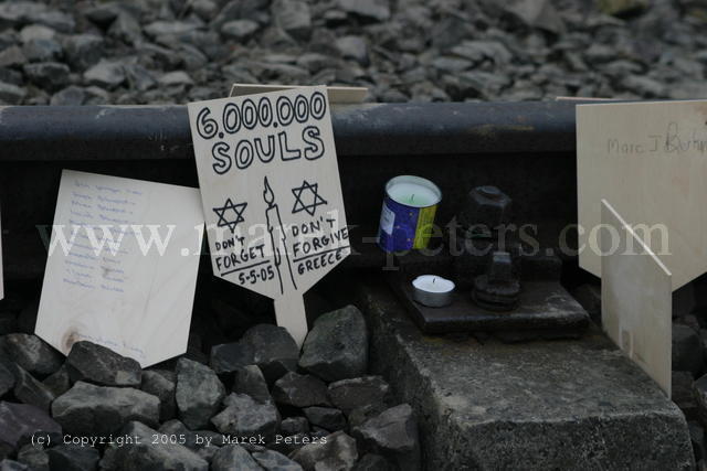 Gedenkschildchen am Gleis des KZ Auschwitz: "6.000.000 Souls - Don't forget - Don't forgive" mit Kerze und Davidstern