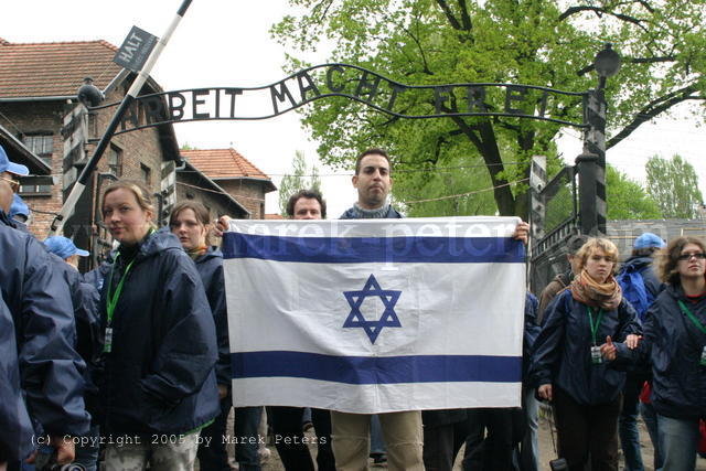 Demonstrant mit Israel-Fahne unter dem Torbogen "Arbeit macht frei" des Konzentrationslagers Auschwitz