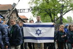Demonstrant mit Israel-Fahne unter dem Torbogen "Arbeit macht frei" des Konzentrationslagers Auschwitz