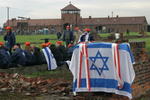 Israel-Fahne auf Ruine eines Kamins einer Gefangenenbaracke, im Hintergrund das Einfahrtstor