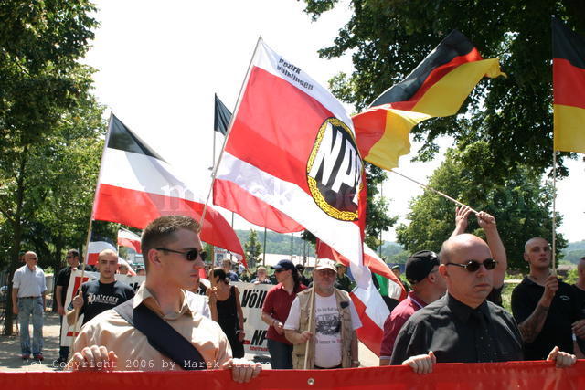 Frank Franz und Peter Marx hinter Transparent vor Fahnen "schwarz-rot-gold" und "schwarz-weiss-rot"