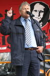 NPD-Parteivorsitzender Udo Voigt mit erhobenem Zeigefinger vor Konterfei von Rudolf Hess
