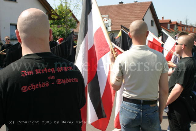 Neonazi - Skinheads mit schwarz-weiss-roten Fahnen und T-Shirt "Im Krieg gegen ein Scheiss System"