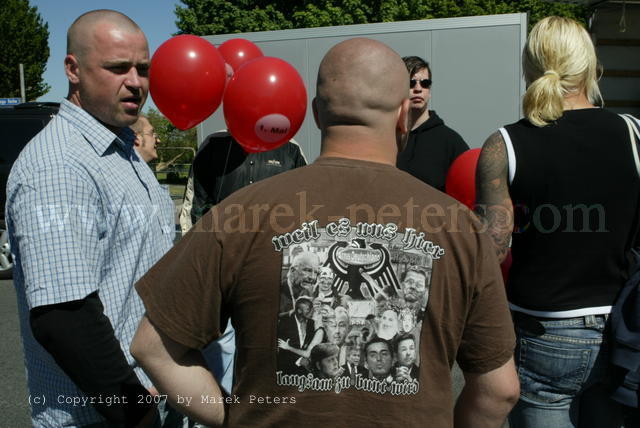 Skinhead mit braunem T-Shirt der Band Landser "Weil es uns hier langsam zu bunt wird"