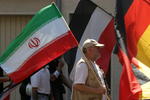 Iranische Fahne vor schwarz-weiss-roter Fahne und neben schwarz-rot-goldener Fahne