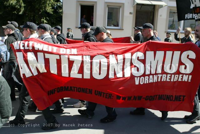 Neonazis mit antisemitischem Transparent "Weltweit den Antizionismus vorantreiben"