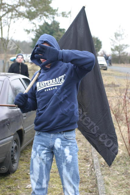 Neonazi mit Pullover "Masterrace Europe" und schwarzer Fahne