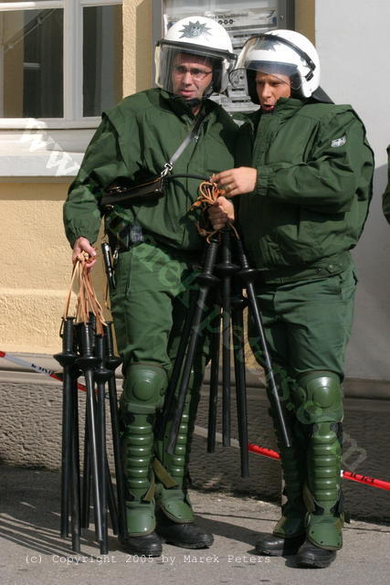 Polizisten in Schutzpanzerung verteilen Schlagstöcke